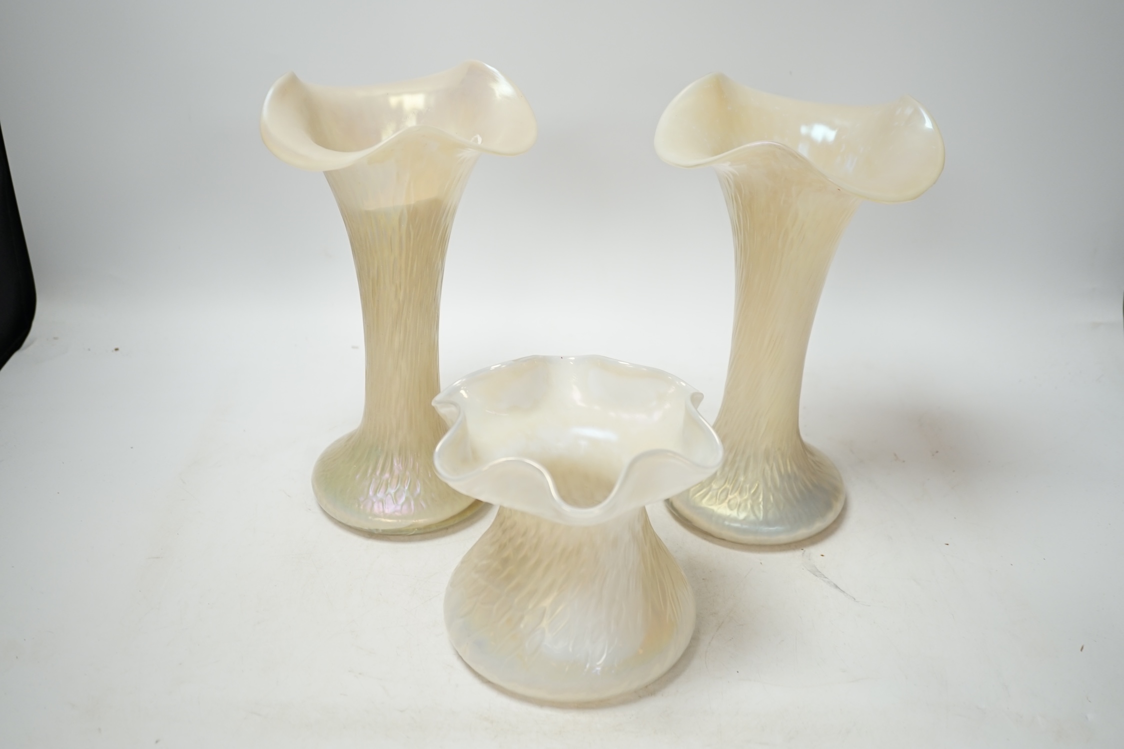 A garniture of three Kralik lustre glass vases, tallest 24cm. Condition - fair to good, splinter chip to rim of one vase